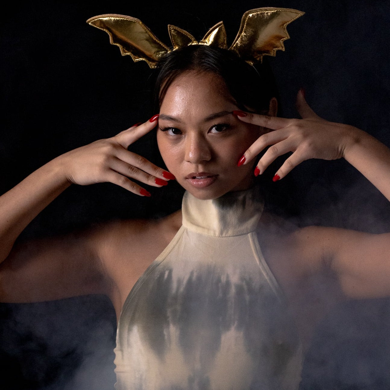 Girl surrounded in smoke, wearing red Instant Mani Co. press-on nails 